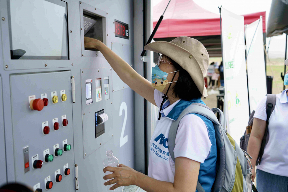 志工們將拾起的寶特瓶投入「好歸塑專車」，讓廢棄塑料空瓶可以直接粉碎、縮小體積，未來將可再製成購物袋、寶特衣、悠遊卡等生活用品